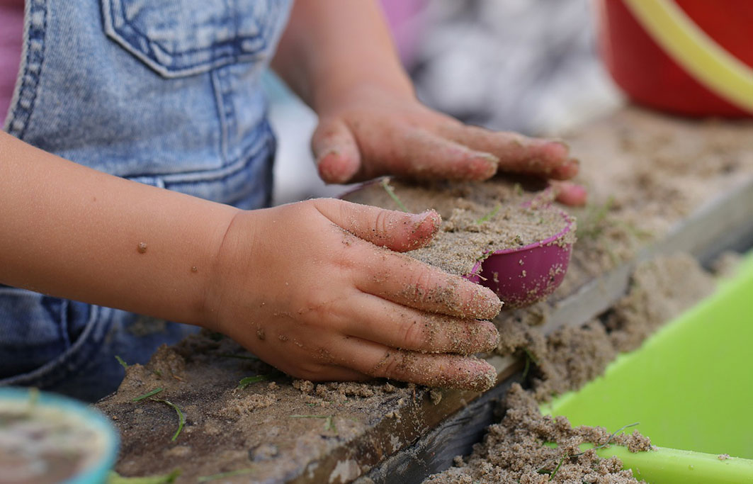 Barn leger med sand